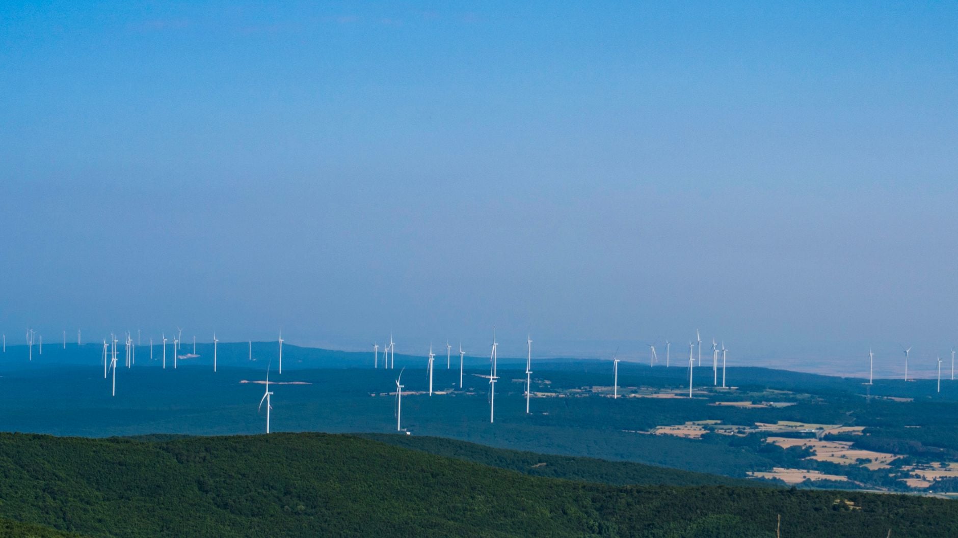 Vindmøller i dansk landskab, elmast og ledninger, solceller på mark, blå himmel
