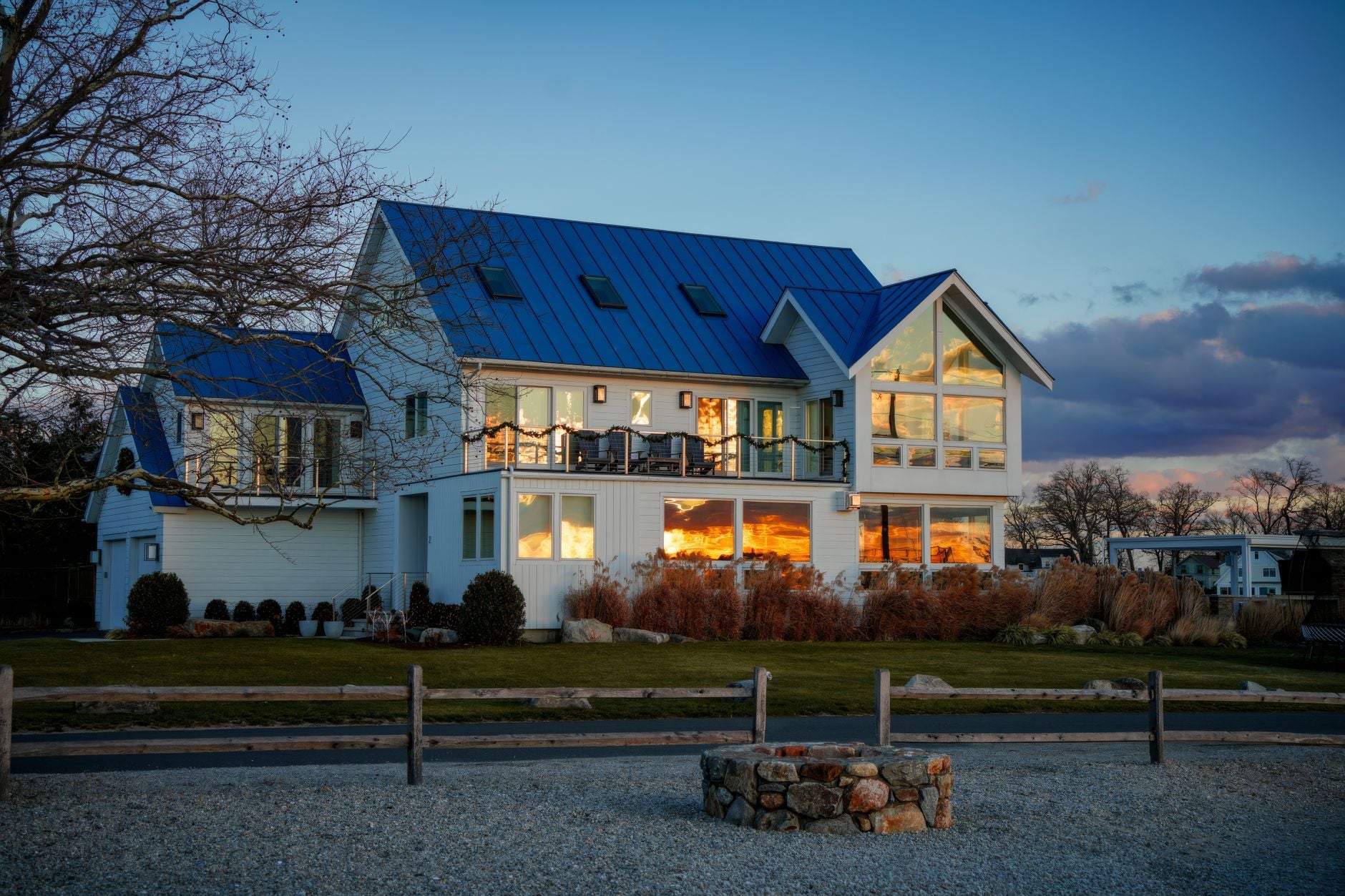 sommerhus i klitlandskab, træterrasse, oplyste vinduer i skumring, elmåler eller elskab på husvæg, dansk kystnatur
